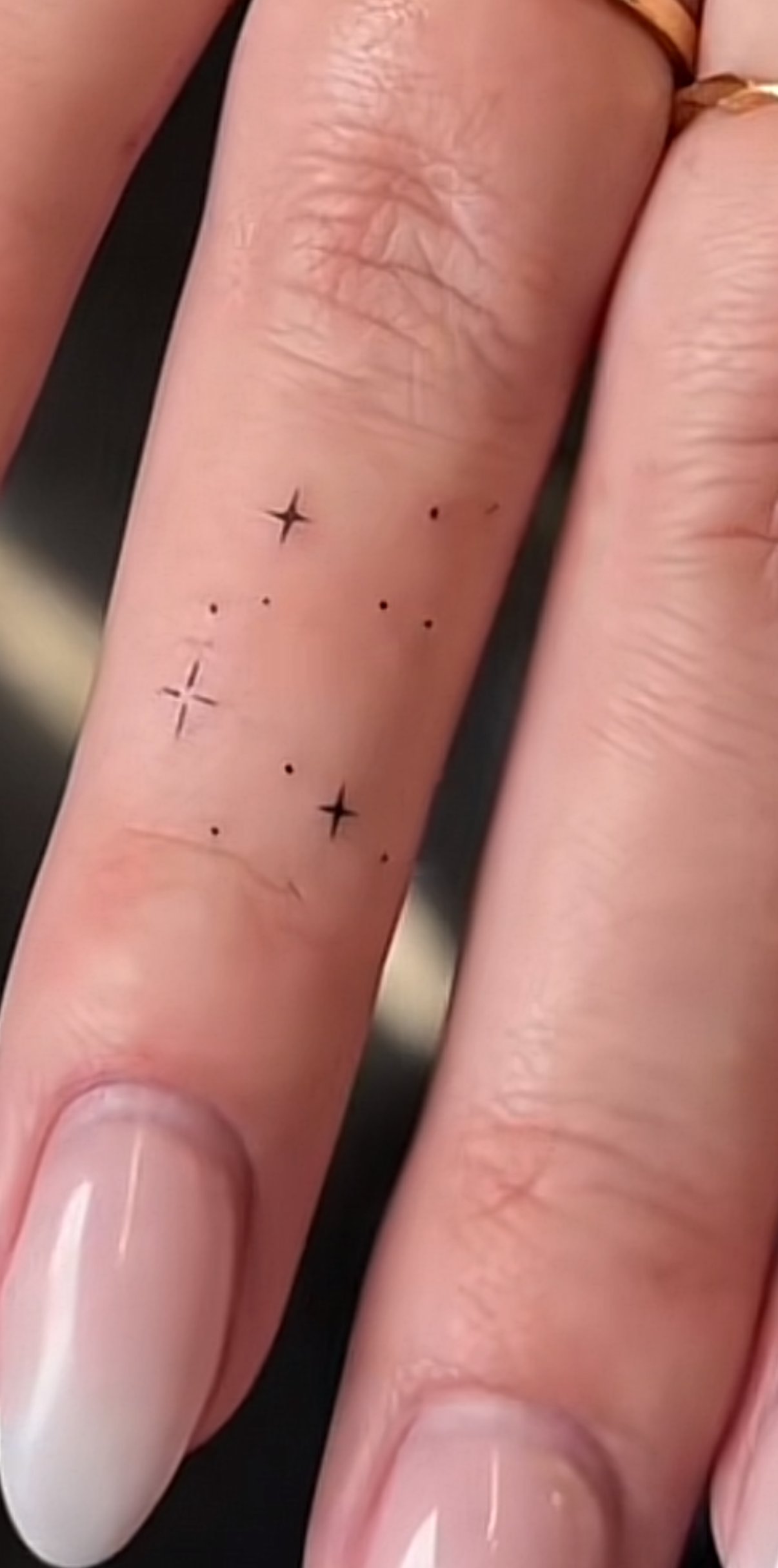 Tiny fine line star and dot tattoos on fingers