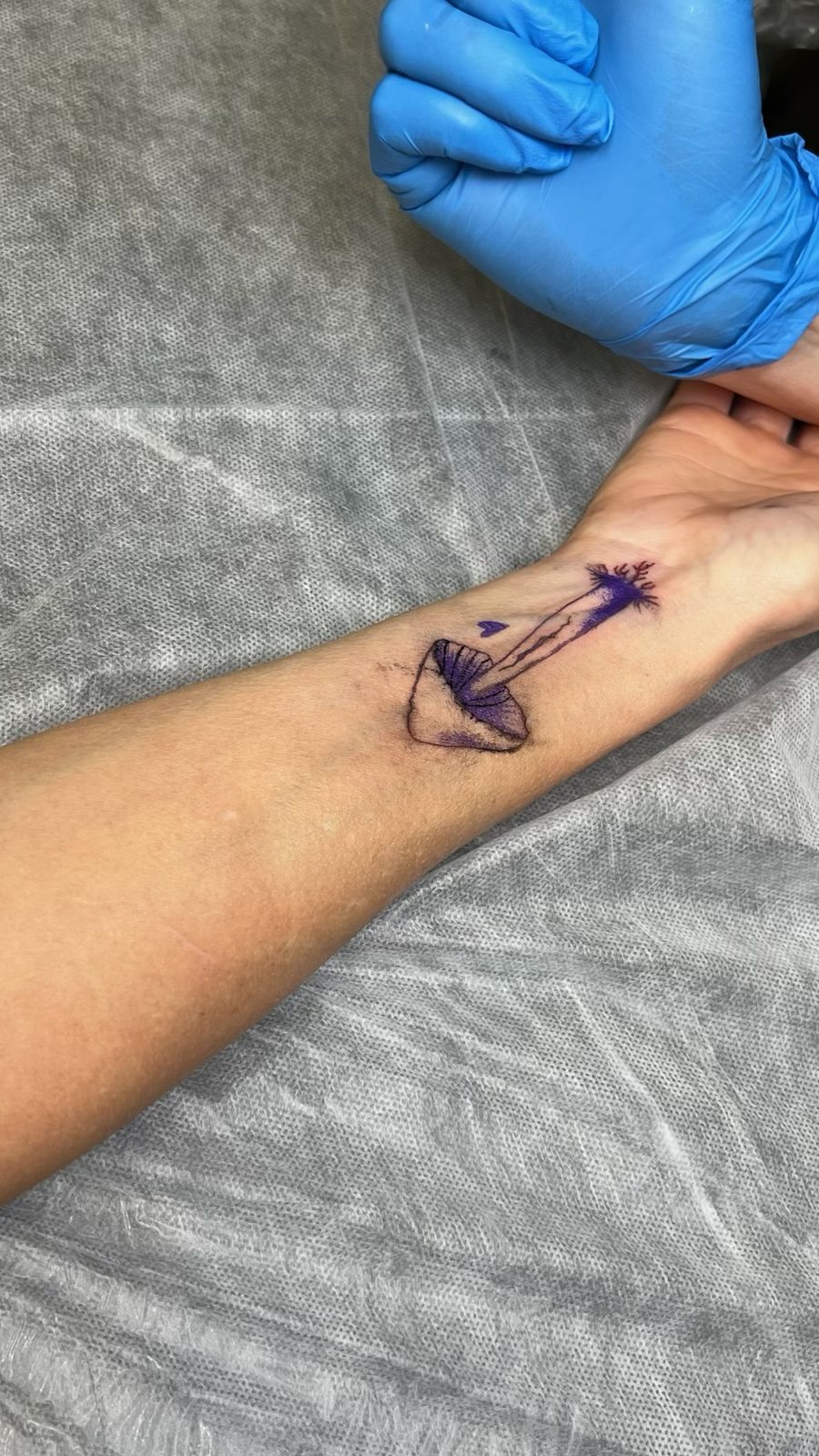Fine line mushroom tattoo with purple color, fresh